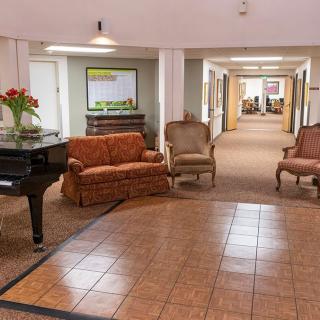 A welcoming lobby featuring a grand piano, comfortable seating, and decorative elements.