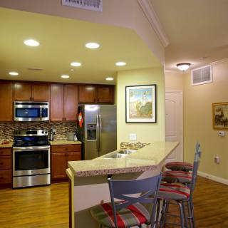 A modern kitchen with stainless steel appliances and a cozy bar seating area.