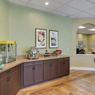 A reception area with green walls, featuring a counter with a popcorn machine and artwork on the walls.
