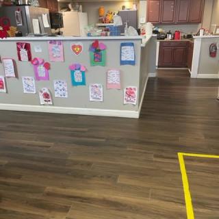 A kitchen area decorated with children's artwork displayed on the counter wall.
