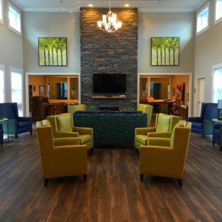 Modern living room featuring a central fireplace, arranged seating, and a chandelier.