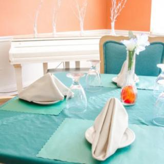An elegantly set dining table with folded napkins and a decorative vase.