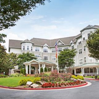 A picturesque view of a large building with landscaped gardens and a welcoming entrance.