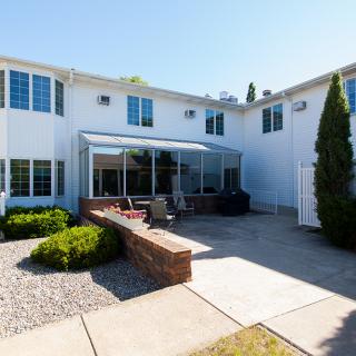 A modern house with a spacious backyard patio and sunroom.
