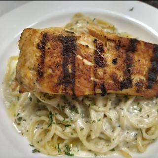 Grilled salmon served over creamy fettuccine pasta.
