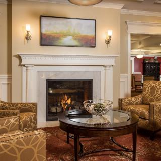 A cozy living room with a fireplace, comfortable seating, and warm lighting.