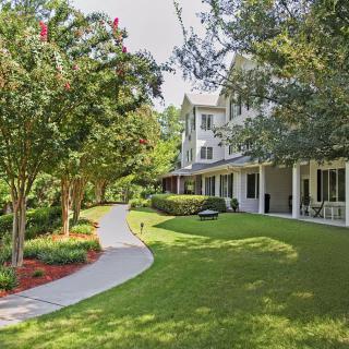 A charming house with a well-maintained lawn and a winding pathway surrounded by trees.