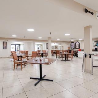An empty dining area with neatly arranged tables and chairs in a restaurant setting.