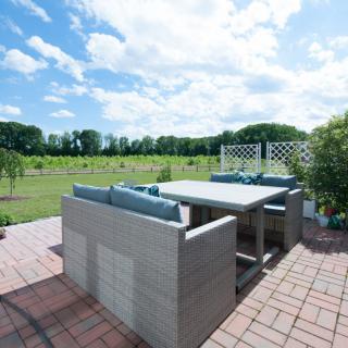 A patio set overlooking a lush green landscape under a partly cloudy sky.