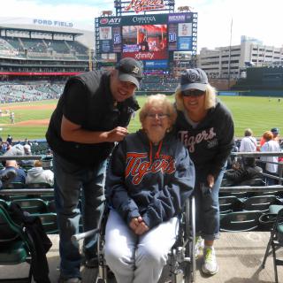 A family enjoying a day at the baseball stadium, with one member in a wheelchair.