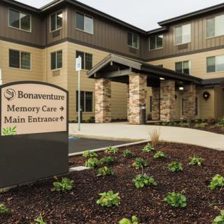 Entrance of a memory care facility with landscaping.