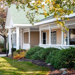 A cozy residential house with a front porch and landscaped yard.