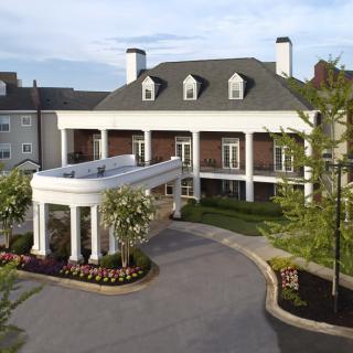 Elegant hotel entrance with classic architectural design and well-maintained landscaping.