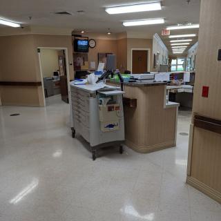 A hospital corridor with a nurse station and medical equipment.
