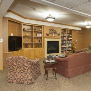 A cozy living room with a fireplace, bookshelves, and comfortable seating.