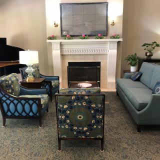A cozy living room with a fireplace, surrounded by comfortable seating and elegant decor.