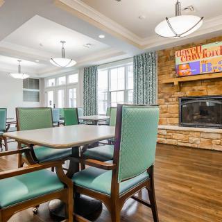 A cozy dining area featuring a fireplace, modern lighting, and comfortable seating.
