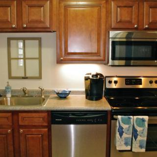 A modern kitchen featuring wooden cabinets and stainless steel appliances.