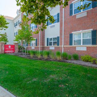 Brick apartment building with well-maintained landscaping.
