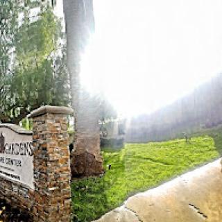 A picturesque view of a welcoming entrance, surrounded by lush greenery and bright sunlight.