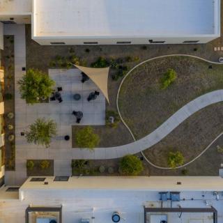 Aerial view of a modern courtyard with a winding pathway and landscaped greenery.