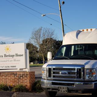 A white truck parked in front of a building with a sign.