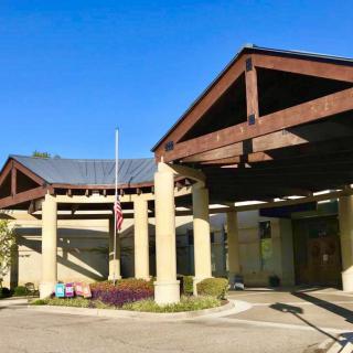 A building entrance with wooden beams and columns under a clear blue sky.