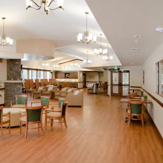 A spacious and well-lit lounge area with comfortable seating and tables.