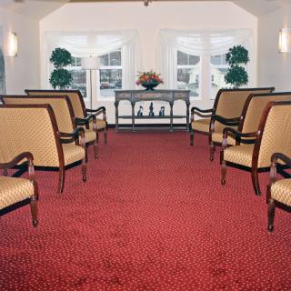 A well-lit waiting area featuring elegant chairs and decorative plants.
