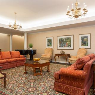 A spacious living room with elegant furnishings and a grand piano.
