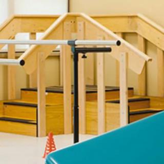 A physical therapy area equipped with handrails and stairs for rehabilitation exercises.