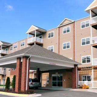 A multi-story residential building with an entrance awning and balconies.