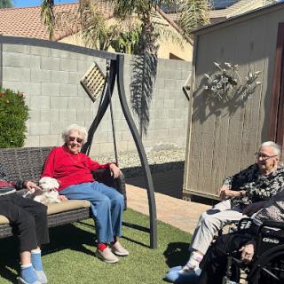 A group of elderly individuals enjoying a sunny day together in the garden.