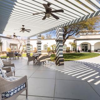 A serene outdoor patio with stylish furniture and a shaded area, perfect for relaxation.