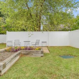 A peaceful backyard with a small patio, seating area, and surrounding trees.