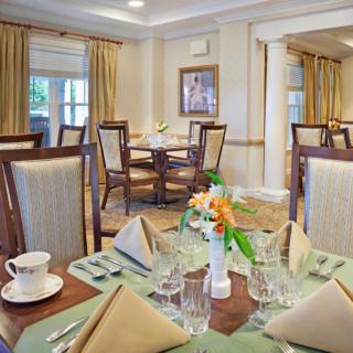 An elegant dining room with a formal table setting, featuring neatly arranged napkins and glassware.