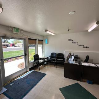 A modern waiting room featuring comfortable chairs and a welcoming reception area with natural light.