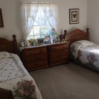 A cozy vintage-style bedroom with twin beds and wooden furniture.