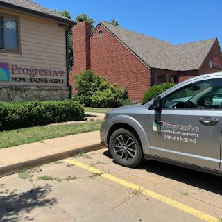 A gray vehicle parked in front of a healthcare facility on a clear day.