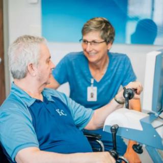 A healthcare professional assists a patient during a therapy session.