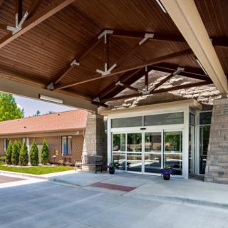 The entrance of a modern building with a pitched roof and glass doors.