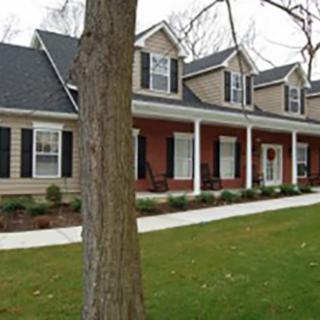A beautiful suburban house with a welcoming front porch and well-maintained landscaping.