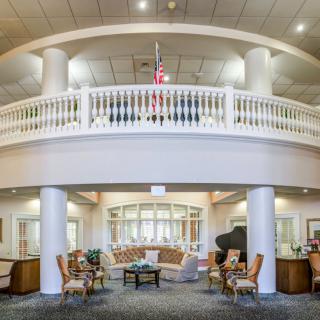 A spacious lobby with elegant seating and a balcony.