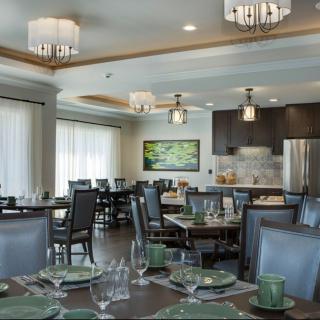 A modern dining room with elegant decor, featuring neatly set tables and stylish chandeliers.