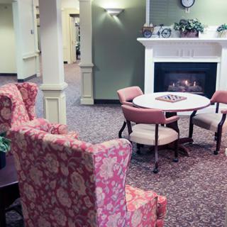 A cozy indoor seating area with a fireplace, table, and chairs.