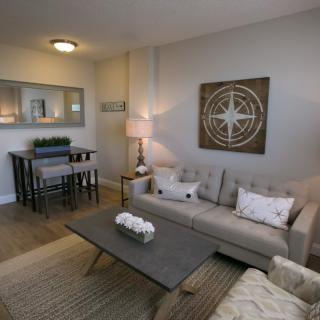 A modern living room with a cozy sofa, stylish coffee table, and dining area.