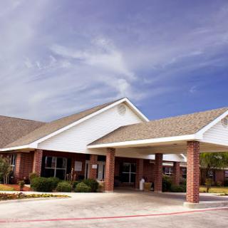 A modern healthcare facility with a welcoming entrance under a bright blue sky.