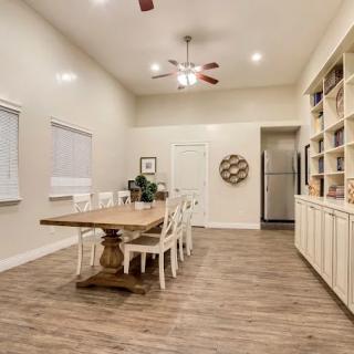 A spacious dining room with a wooden table, chairs, and built-in bookshelves.