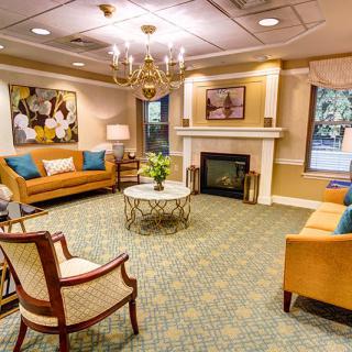 A cozy and elegant living room with comfortable seating, a central coffee table, and a classic chandelier.