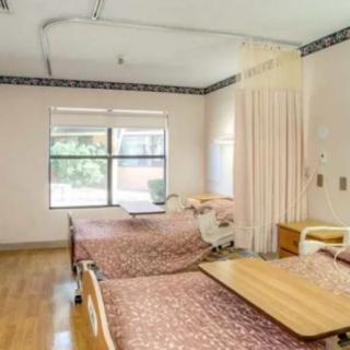 A hospital room with two beds and medical equipment.